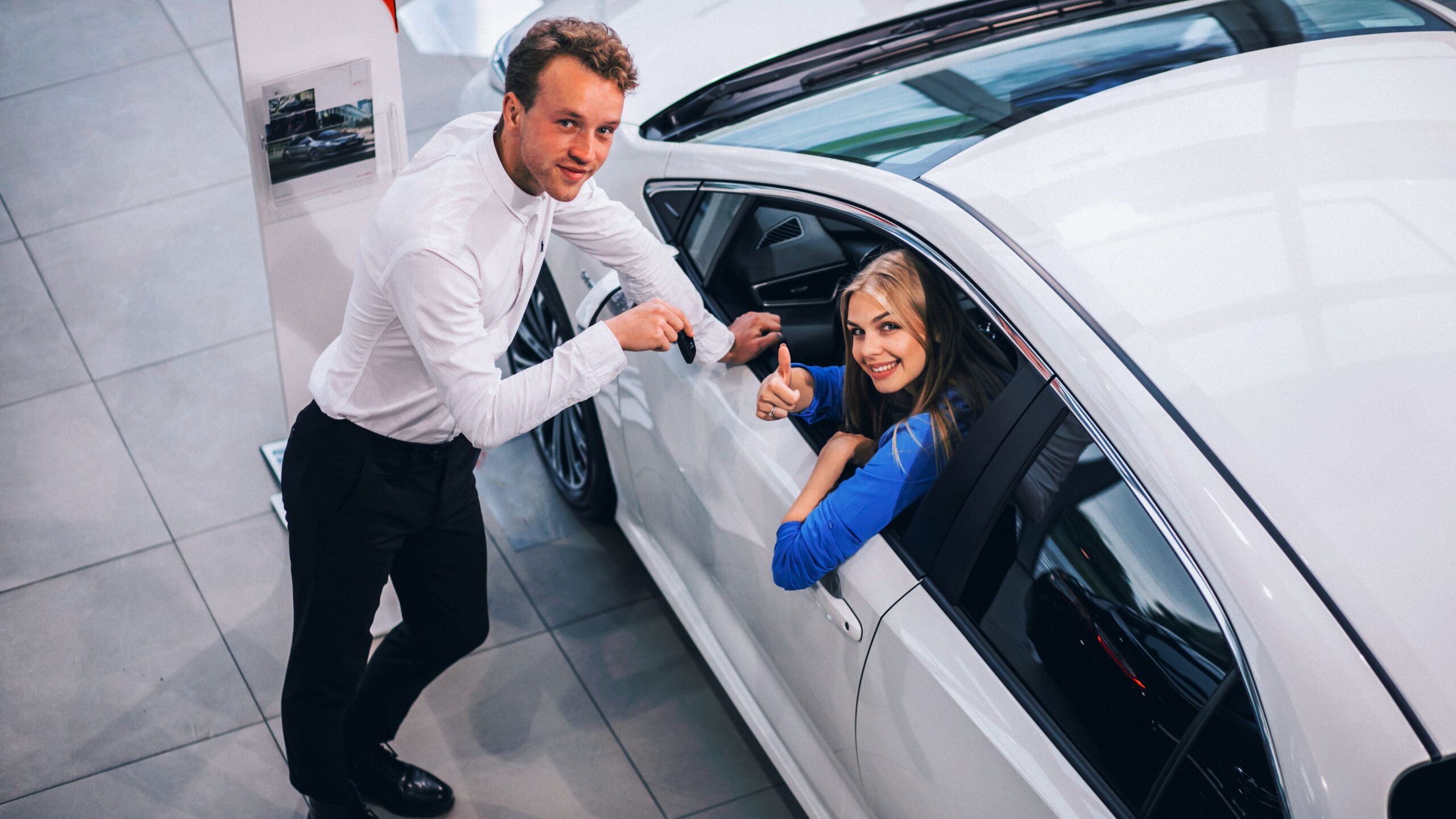 Woman choosing a car in a car showroom